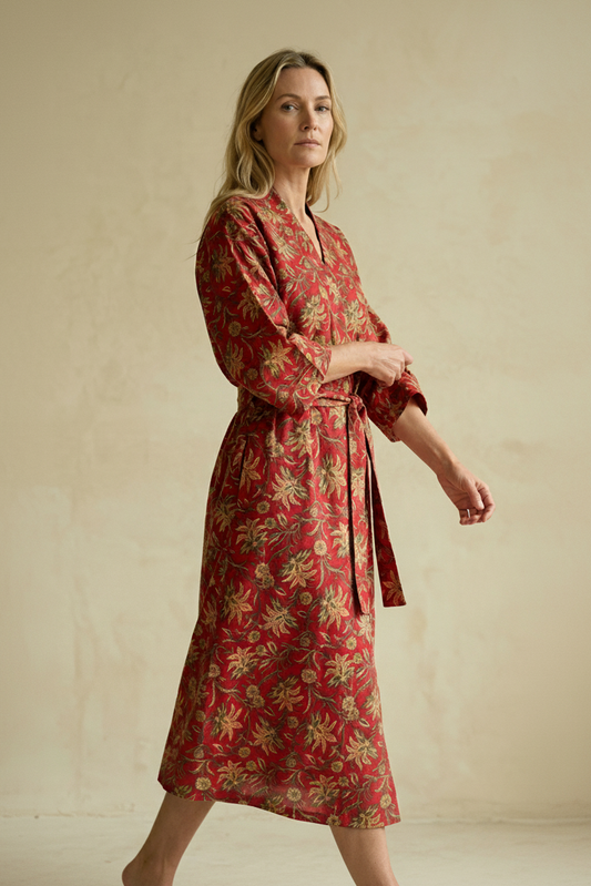 Woman wearing a red floral dress against a beige background