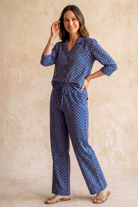 Woman wearing a blue patterned outfit against a beige background