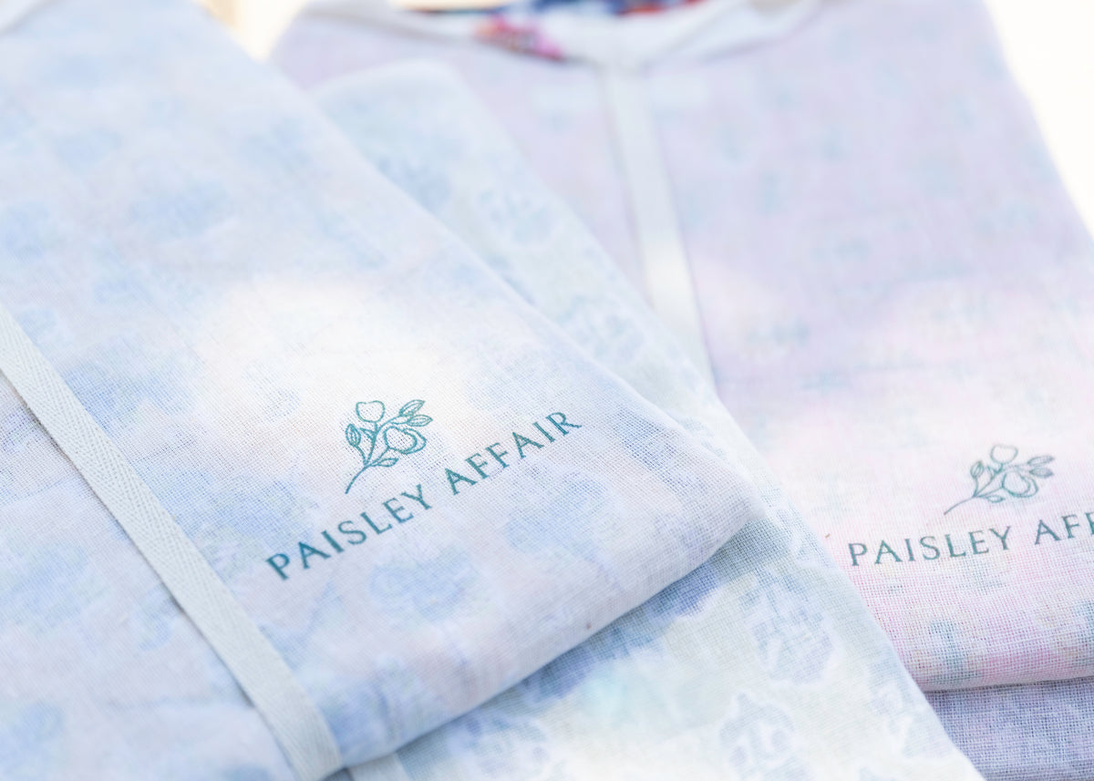 Paisley Affair loungewear folded in reusable muslin bags printed with the brand logo