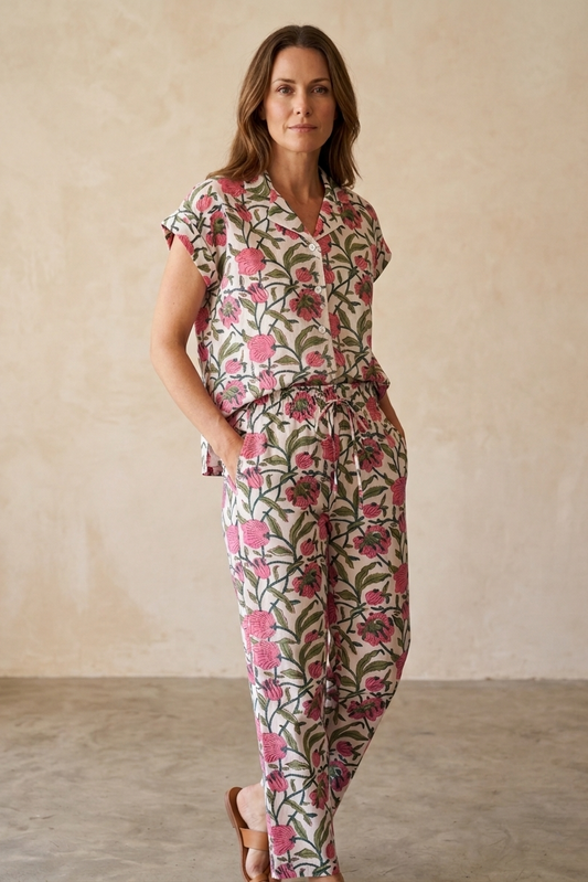 Woman wearing a floral pajama set against a plain background