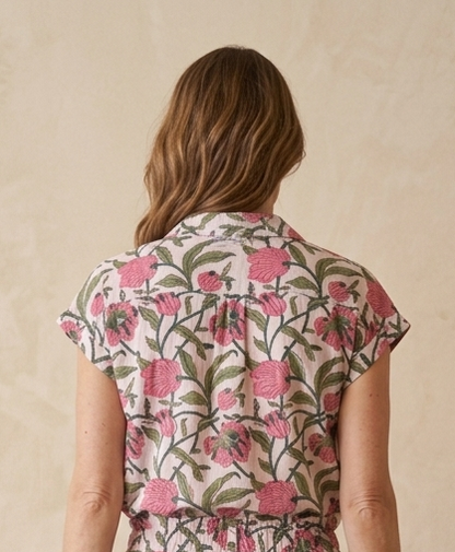 Woman wearing a floral jumpsuit against a beige background