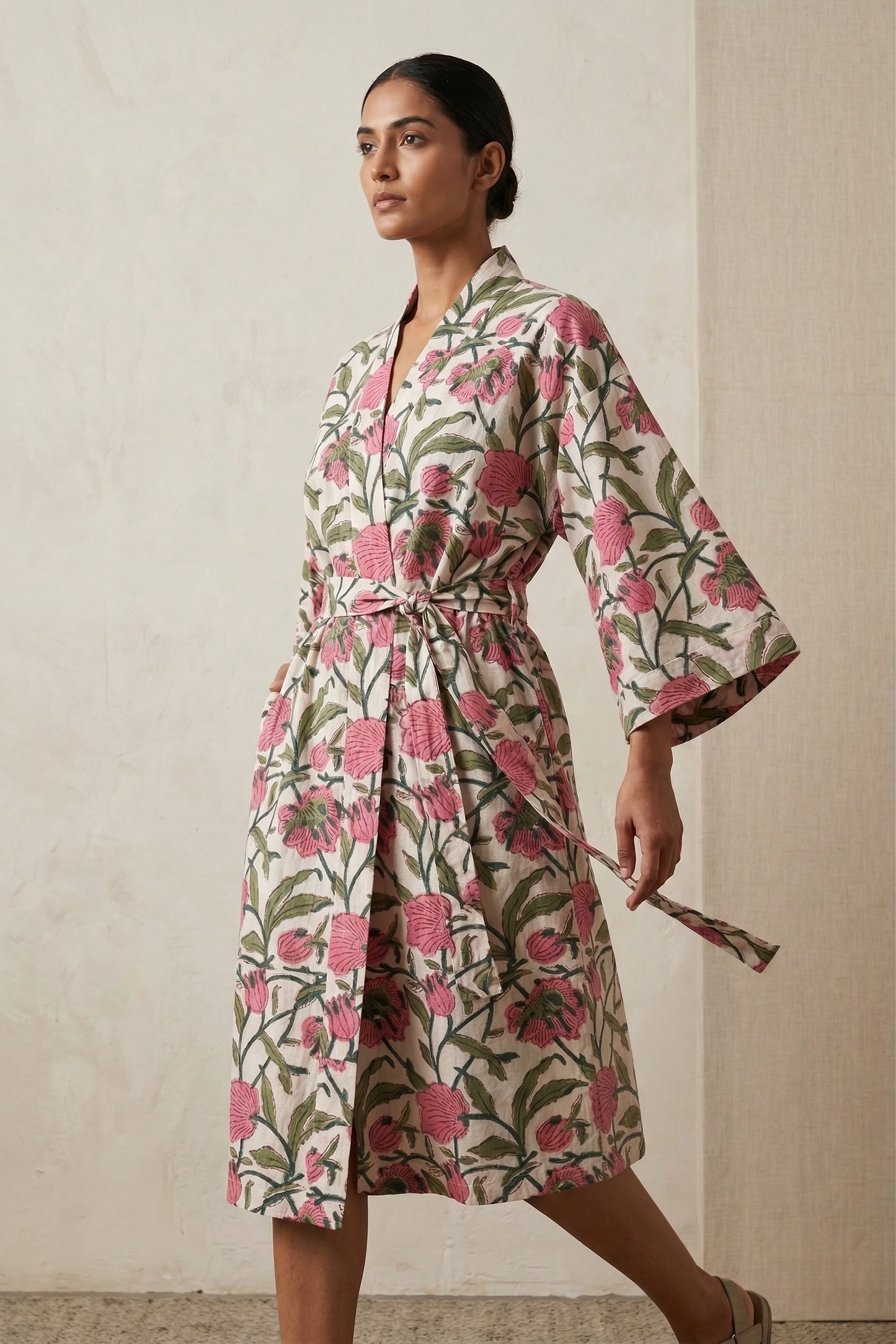 Woman wearing a floral dress against a neutral background